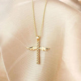 Collier croix avec ailes d'ange dorées