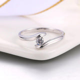 Bague en or blanc barrette courbée et zircone